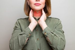 Woman touching glands on the side of the neck.