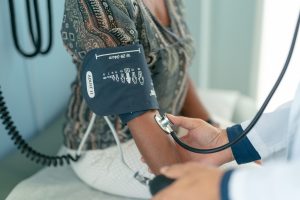 A woman getting her blood pressure checked at a doctor's office.