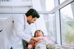 A pediatric gastroenterologist checking a child for symptoms of liver disease.